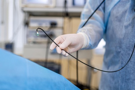Hand of a doctor holding a tube used during a colonoscopy procedure